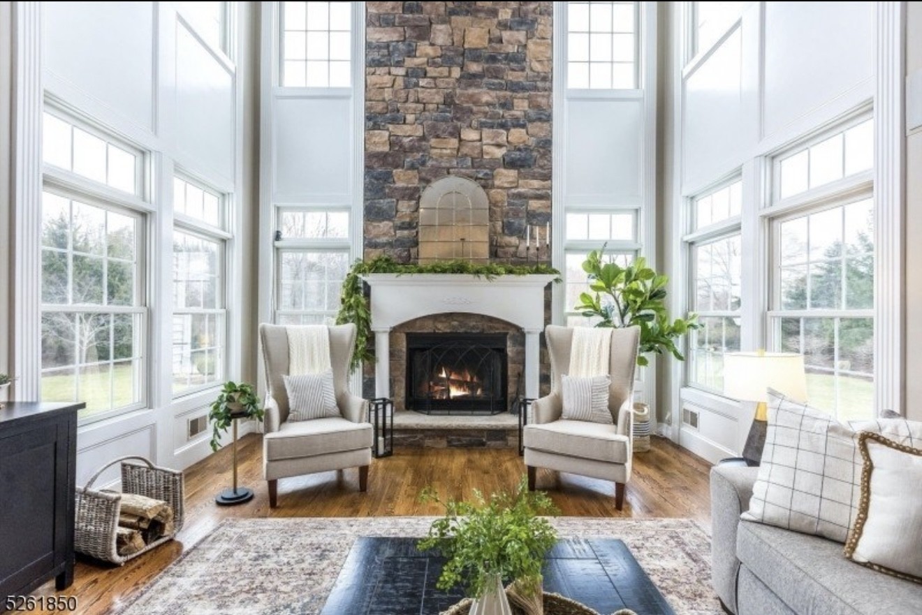 Living room with tall windows and a stone fireplace